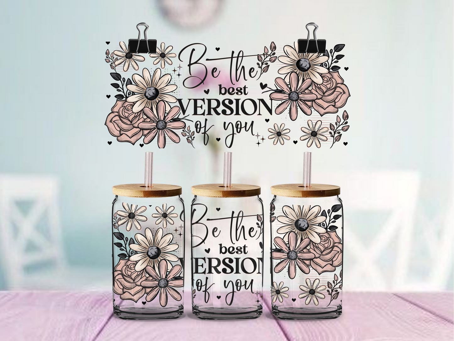 glass tumbler with floral designs and motivational text on a blurred background