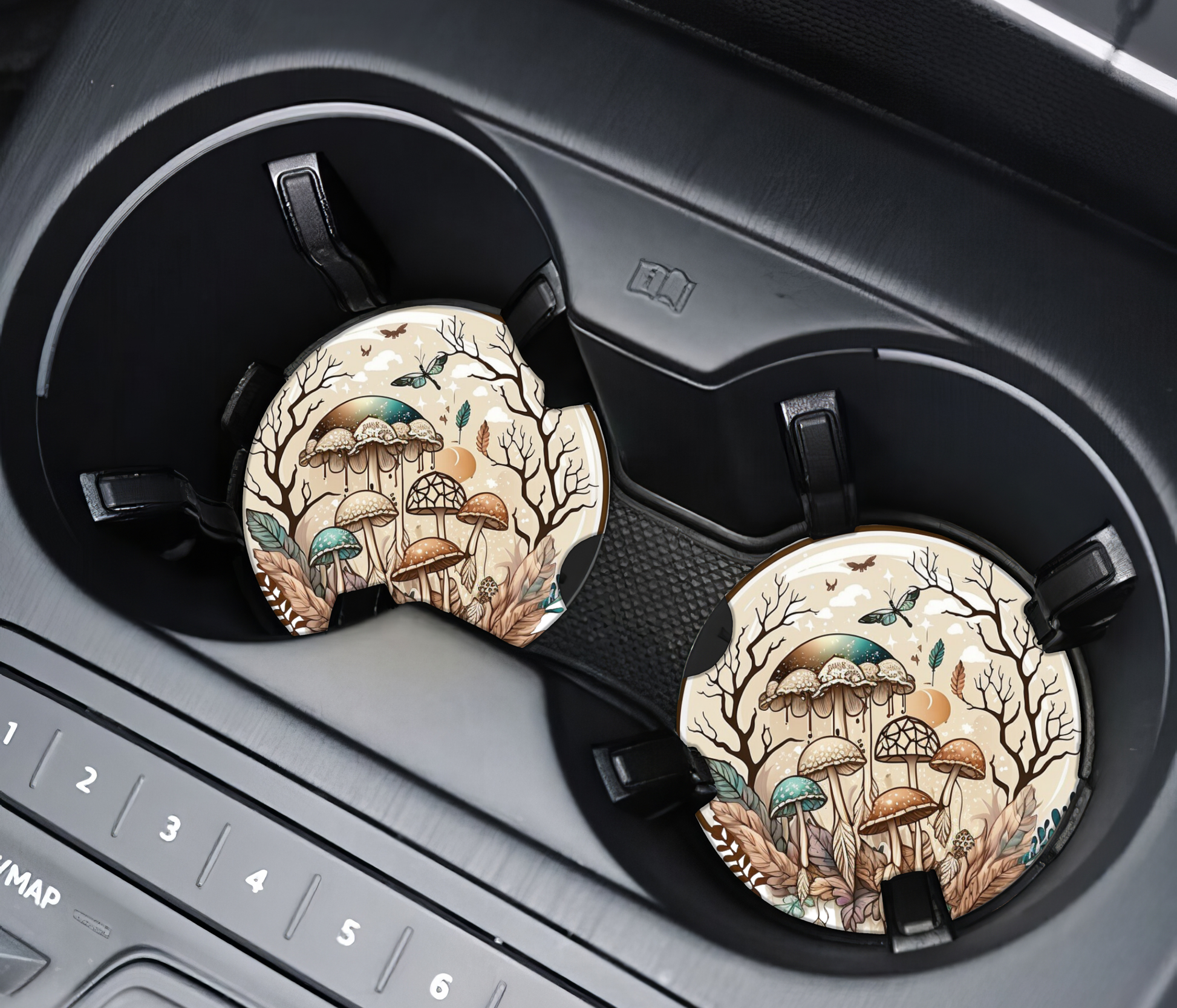 Two car cup holders with decorative coasters featuring nature-themed designs.