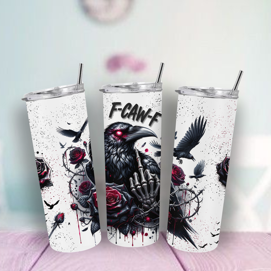 Tumbler with a design of a black bird, roses, and a hand middle finger up on a light surface.