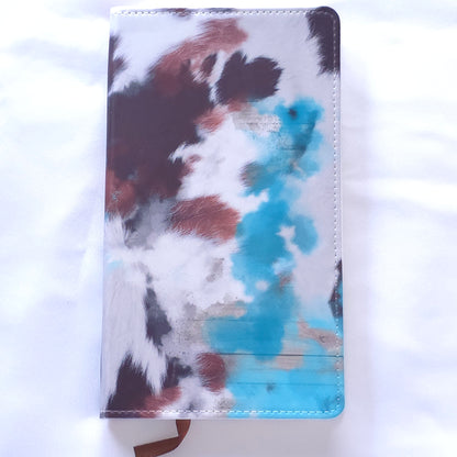 Notebook with cow print cover on a white background